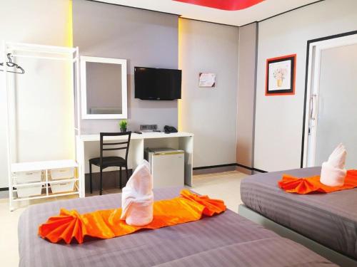 um quarto de hotel com duas camas com os pés para cima em เสาวลักษณ์ เรสซิเด้นท์ em Khon Kaen