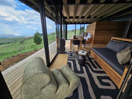 a living room with a couch and a large window at Eagle View on Beumont in Dullstroom