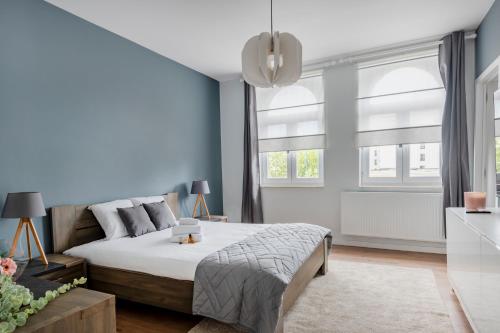 a bedroom with a bed and two windows at Evere EU Residence in Brussels