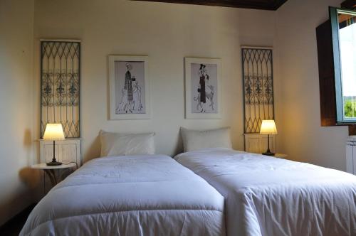 two white beds in a bedroom with two lamps at Villa 282 in Calheiros