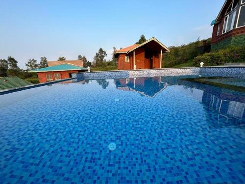 a large blue swimming pool in front of a house at Holygram Krushi Paryatan in Panchgani