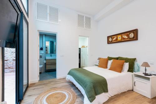 - une chambre blanche avec un lit et une télévision dans l'établissement Veoapartment Relator Patio, à Séville