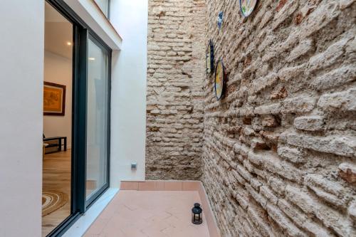 Cette chambre est dotée d'un mur en pierre avec une horloge. dans l'établissement Veoapartment Relator Patio, à Séville