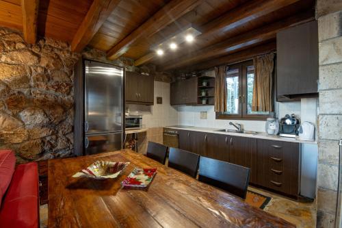 a kitchen with a wooden table with chairs and a counter at Villa Maria in Synikia Mesi Trikalon