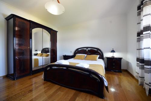 ein Schlafzimmer mit einem Bett und einem großen Spiegel in der Unterkunft Villa 281 in Esposende