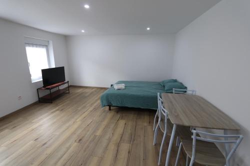 a bedroom with a bed and a wooden floor at Homeday Studio 1 Strasbourg / Mittelschaeffolsheim in Mittelschaeffolsheim