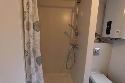 a bathroom with a shower with a shower curtain at Homeday Studio 1 Strasbourg / Mittelschaeffolsheim in Mittelschaeffolsheim
