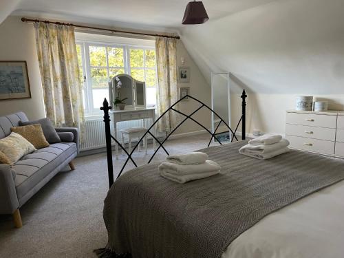 1 dormitorio con 1 cama con toallas en Cottages at Woodlands, Dormer, en Wareham