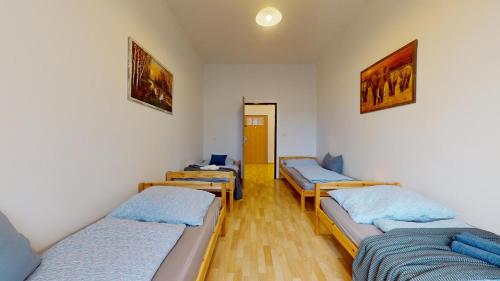 Cette chambre comprend 4 lits et un couloir. dans l'établissement Apartmán Esser 4, à Milovice