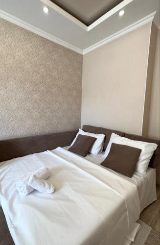 a bedroom with a large white bed with two pillows at Двухкомнатная элитка Золотой Квадрат in Bishkek