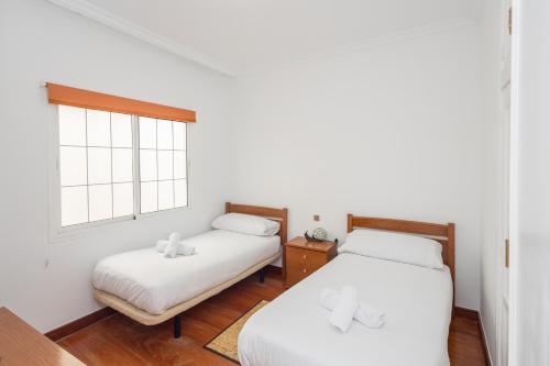2 camas en una habitación con ventana en Gravina House 2BR - 2 min to Las Canteras Beach, en Las Palmas de Gran Canaria