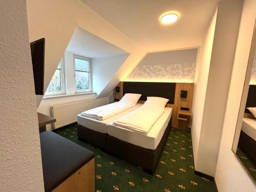 a bedroom with two beds in a small room at Hotel Gasthof zur Heinzebank in Wolkenstein