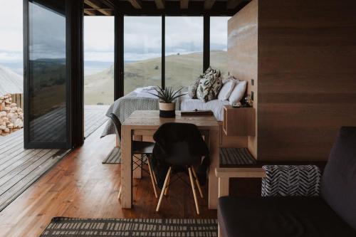 a bedroom with a bed and a table with a view at Eagle View on Beumont in Dullstroom