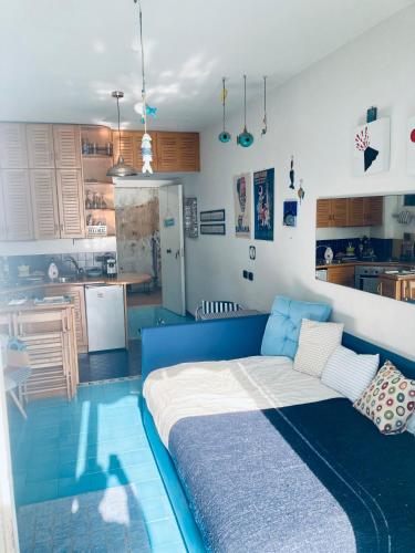 un soggiorno con divano blu e una cucina di La Perla di Posillipo a Napoli