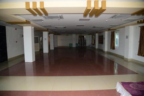 a hallway with a large room with white walls and a ceiling at Hotel AS Lagoon in Bhubaneshwar