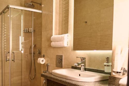 a bathroom with a sink and a shower at City Stay Bishkek in Bishkek