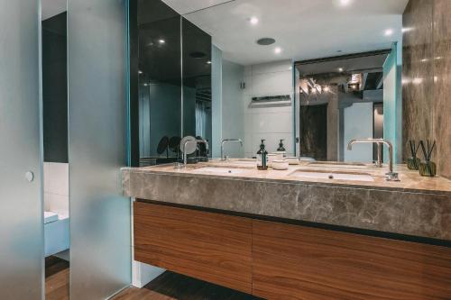 a bathroom with a sink and a large mirror at Immaculate 2-Bed Loft Apartment In Central London in London