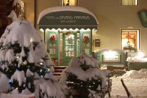 een kerstwinkel met een kerstboom bedekt met sneeuw bij Hotel Du Grand Paradis - 1899 Auberge Boutique in Cogne