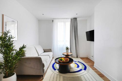 un salon avec un canapé et une table dans l'établissement Résidence Sacré Coeur, à Paris