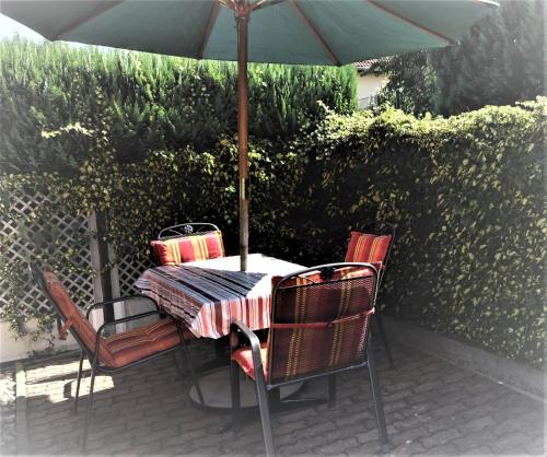 una mesa y sillas bajo una sombrilla en un patio en Ferienhaus Sylvia in Basedow, en Basedow