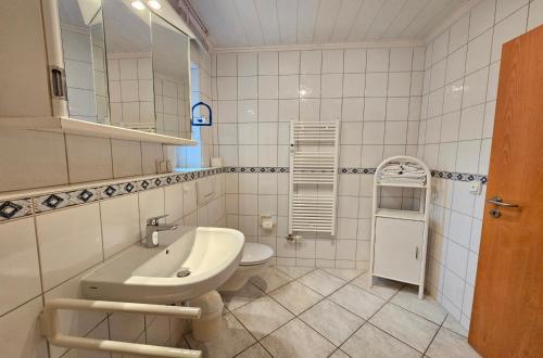 une salle de bains avec lavabo, baignoire et toilettes dans l'établissement Am Schloonsee Haus B, à Heringsdorf