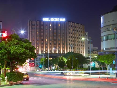a building with a sign on top of it at night at Hotel Rocore Naha in Naha