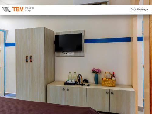 a room with a cabinet with a tv on a wall at The Baga Domingo-TBV in Baga