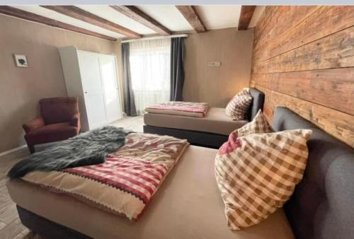 Cette chambre comprend deux lits, un canapé et une chaise. dans l'établissement Ferienwohnung mit WiFi und 2 Schlafzimmern - b45533, à Ipsheim