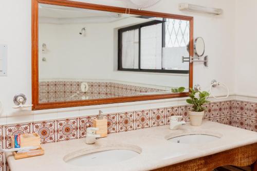 ein Badezimmer mit zwei Waschbecken und einem großen Spiegel in der Unterkunft Luho 41 Penthouse in Bangalore