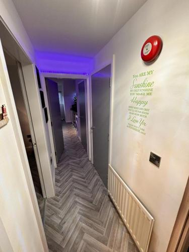 a hallway with a staircase with a red clock on the wall at The Red Door Holiday Let Limavady in Limavady