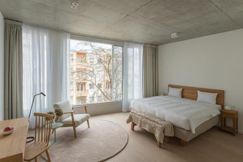 a bedroom with a bed and a large window at Carlotta Apartments in Berlin