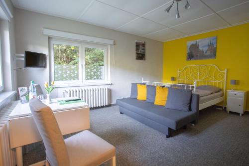 a living room with a couch and a bed at Pension Am Waldesrand in Ilmenau