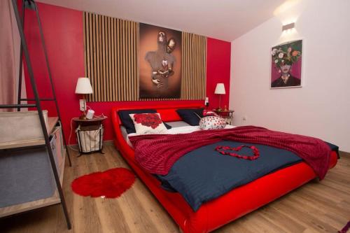 une chambre avec un grand lit avec une tête de lit rouge dans l'établissement Love House SPA SAUNA terrasse, à Aulnay-sous-Bois