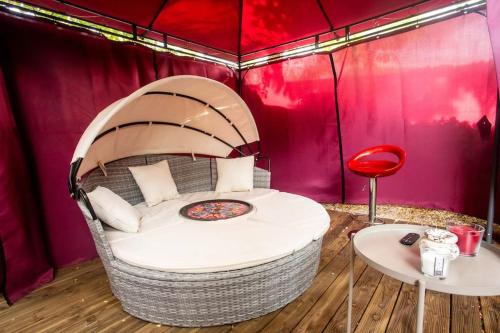 - une chambre avec un lit dans une tente avec une table dans l'établissement Love House SPA SAUNA terrasse, à Aulnay-sous-Bois