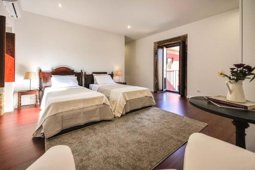 a bedroom with two beds and a table with chairs at Villa 278 in Varziela