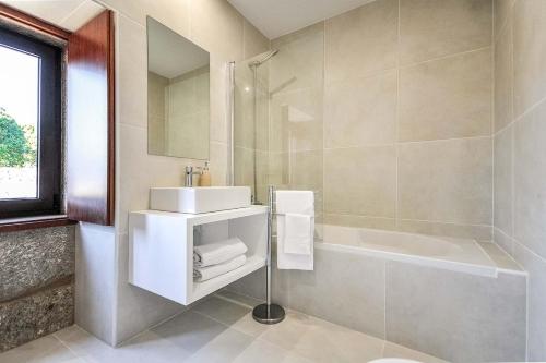a bathroom with a sink and a bath tub at Villa 278 in Varziela