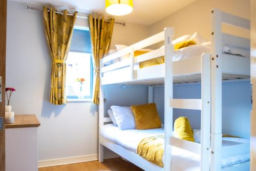 1 dormitorio con literas y cortinas amarillas en Newly furnished Appartment near Train Station wolverhampton en Wolverhampton