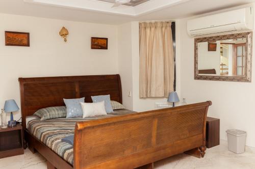 a bedroom with a large wooden bed with blue pillows at Luho 41 Penthouse in Bangalore
