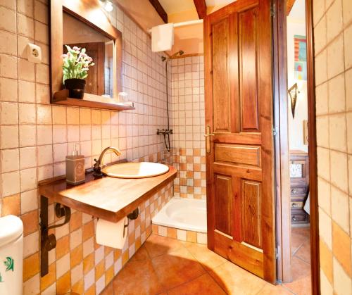 a bathroom with a sink and a bath tub at Casa Rural Fuente del Arca Montejo in Montejo de la Sierra