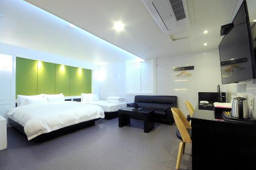 釜山的住宿－WA酒店，酒店客房配有一张床、一把椅子和一张书桌