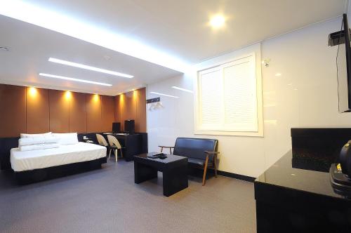 a bedroom with a bed and a table and chairs at WA Hotel in Busan