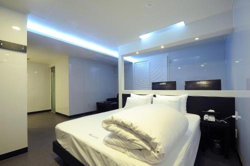 a bedroom with a bed with a pillow on it at WA Hotel in Busan