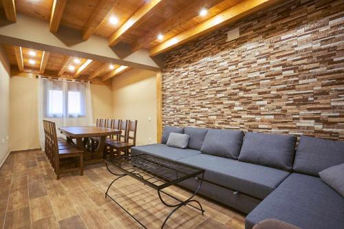 sala de estar con sofá y pared de ladrillo en Casa Rural Nueve Villas, en Amusco