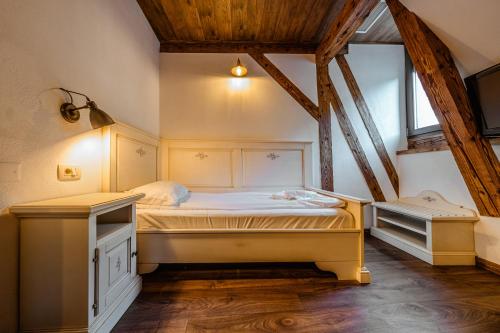 a small bedroom with a bed in a attic at CASA CHITIC - HOTEL & RESTAURANT- Str Nicolae Balcescu 13 in Braşov