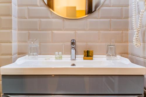 a bathroom with a sink and a mirror at CASA CHITIC - HOTEL & RESTAURANT- Str Nicolae Balcescu 13 in Braşov