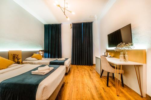 a hotel room with two beds and a desk at CASA CHITIC - HOTEL & RESTAURANT- Str Nicolae Balcescu 13 in Braşov