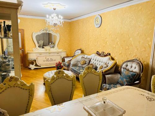 sala de estar con sillas, sofá y espejo en Ganclik apartment by Baku housing en Bakú