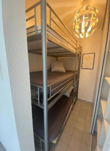 Cette chambre comprend 2 lits superposés et un lustre. dans l'établissement Appartement typeT2bis climatisé à 150m de la plage, à La Grande Motte