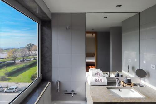 uma casa de banho com 2 lavatórios e uma grande janela em HM - Ocean Breeze Delight em Matosinhos