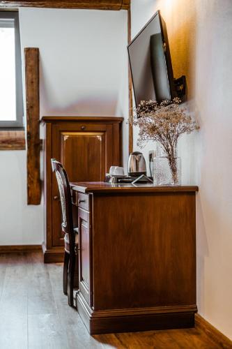 a wooden desk with a television on top of it at CASA CHITIC - HOTEL & RESTAURANT- Str Nicolae Balcescu 13 in Braşov